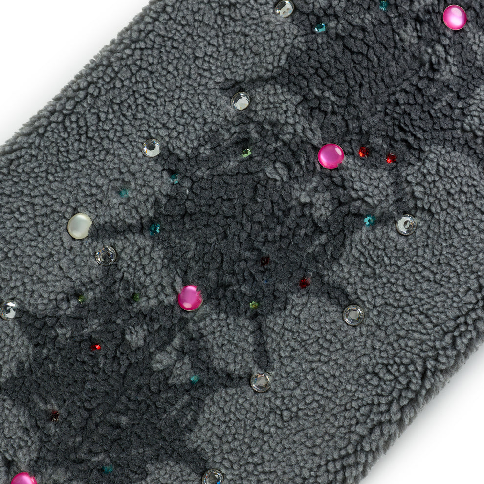Close-up of gray sherpa fleece pant with scattered rhinestones and pink embellishments.