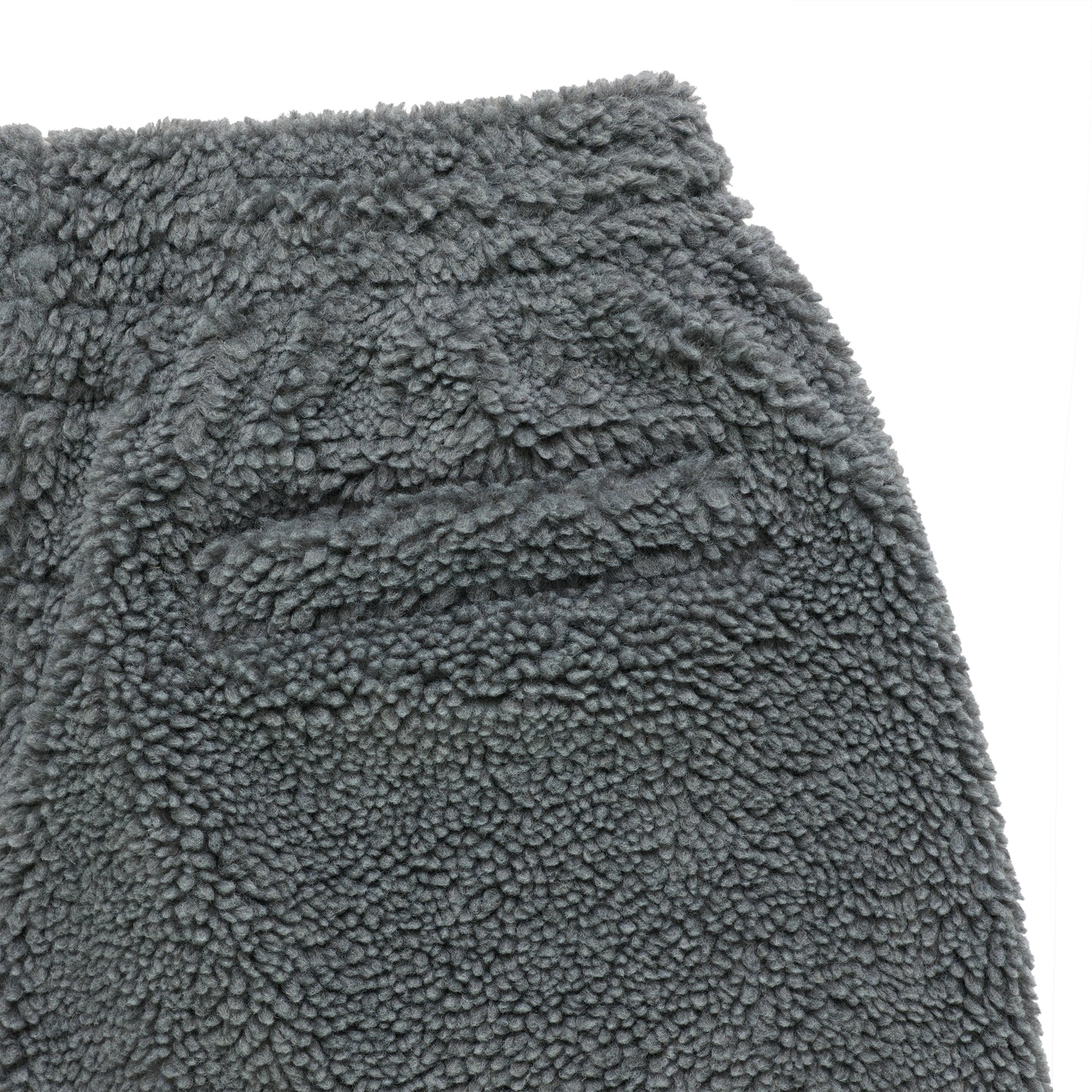 Close-up of gray sherpa fleece pant with textured material and pocket detail.