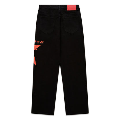 Black denim pants with a large red star graphic on the upper left leg and a red branded leather back patch.