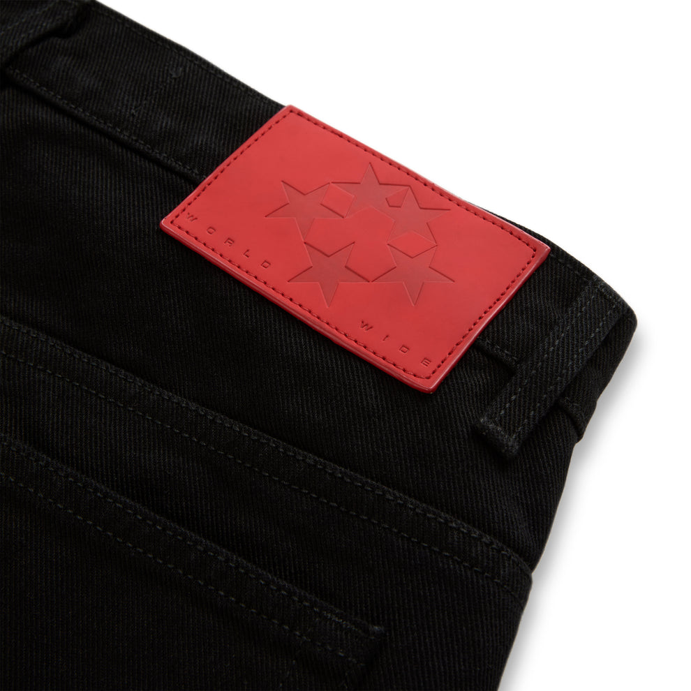 Black denim jeans with a red leather back patch featuring embossed stars and "WORLD WIDE" branding.