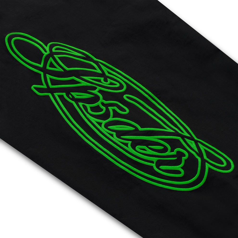 Black nylon track pant with vibrant green embroidered script graphic.
