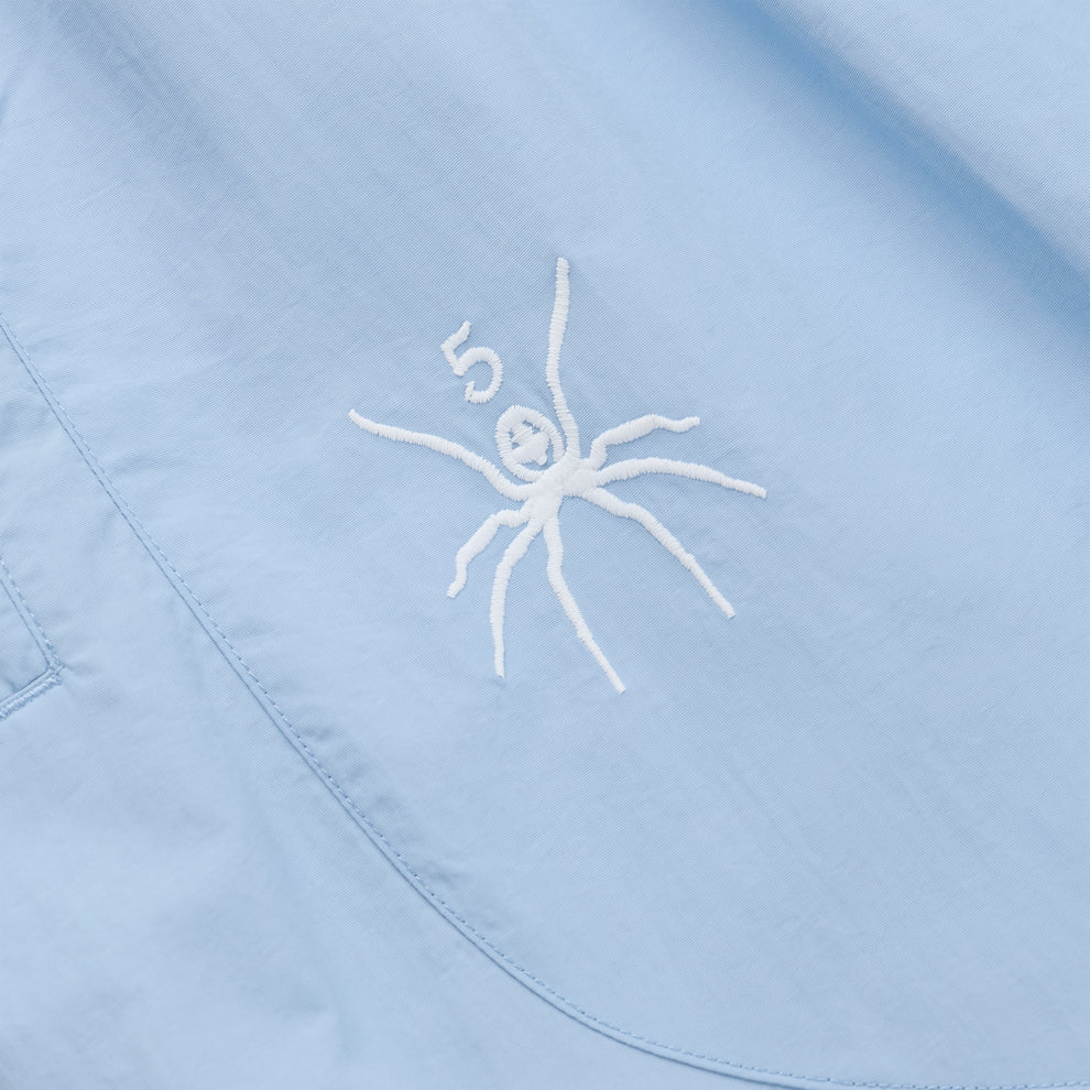 Light blue nylon track pant with white embroidered spider graphic and "5".