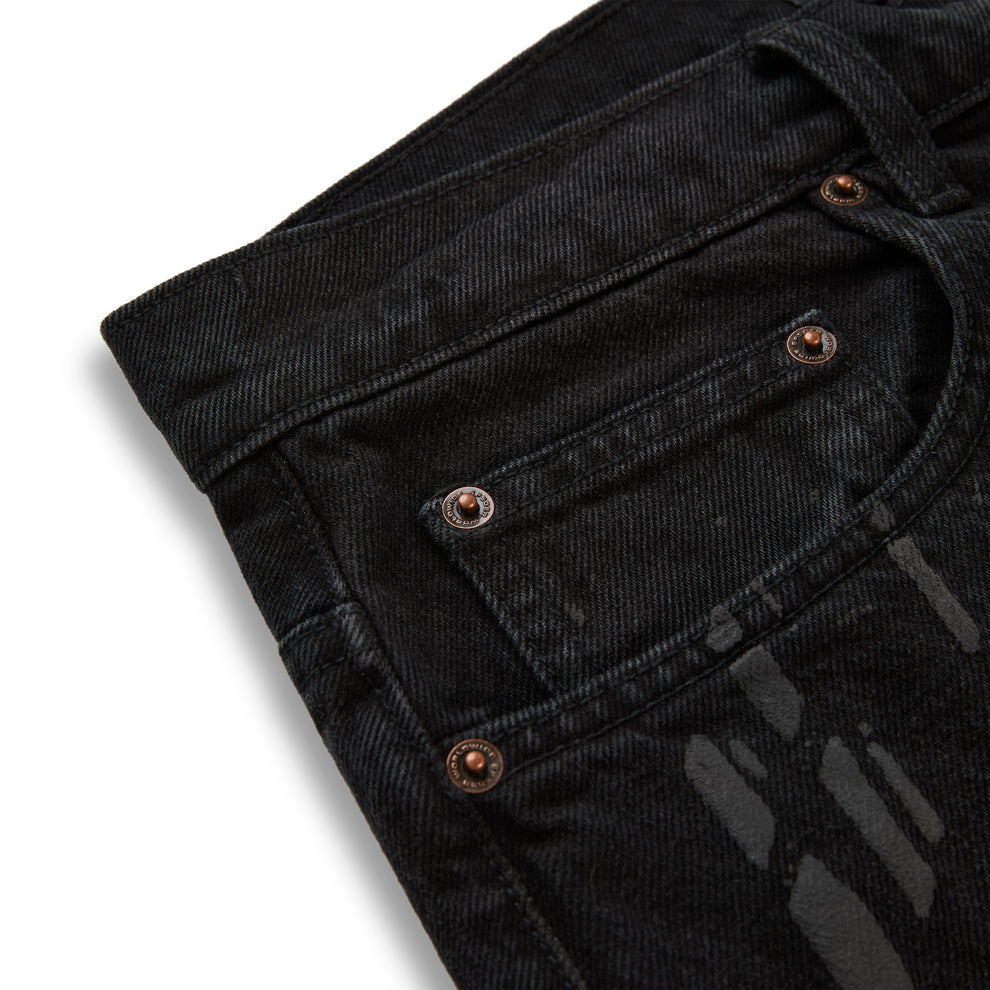 Black denim pants with all-over tire track design and custom branded copper hardware.