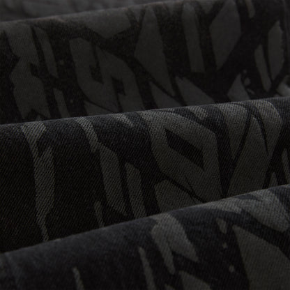 Close-up of black denim with a subtle all-over tire track design.