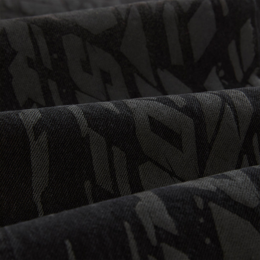 Close-up of black denim with a subtle all-over tire track design.
