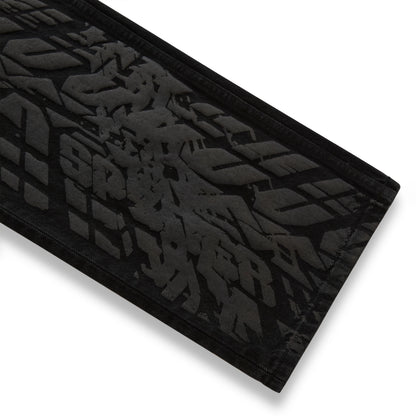 Black denim pant with all-over tire track design.
