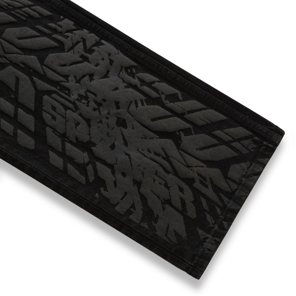 Black denim pant with all-over tire track design.