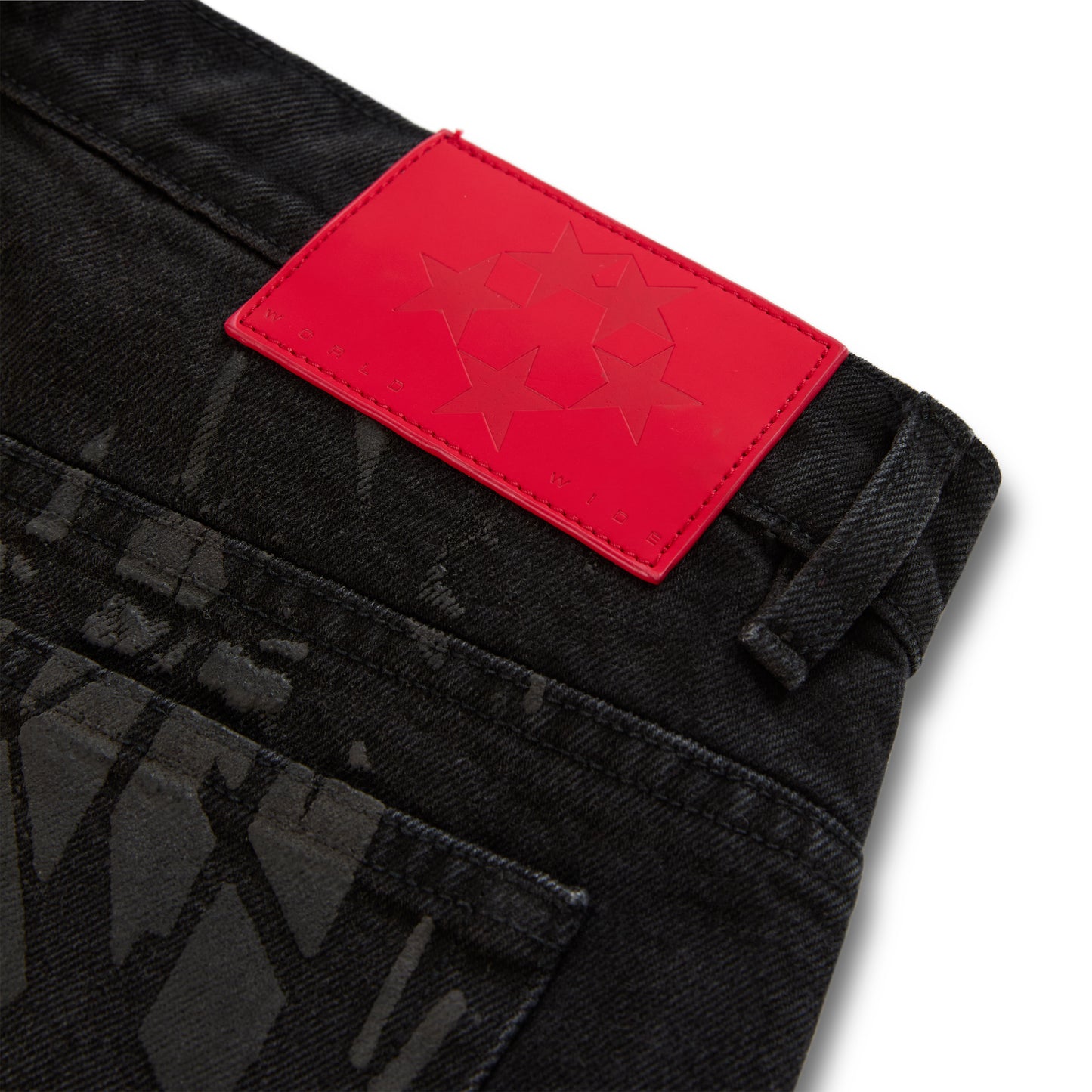 Black denim pant with all-over tire track design and a red branded leather back patch with stars.