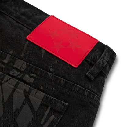 Black denim pant with all-over tire track design and a red branded leather back patch with stars.