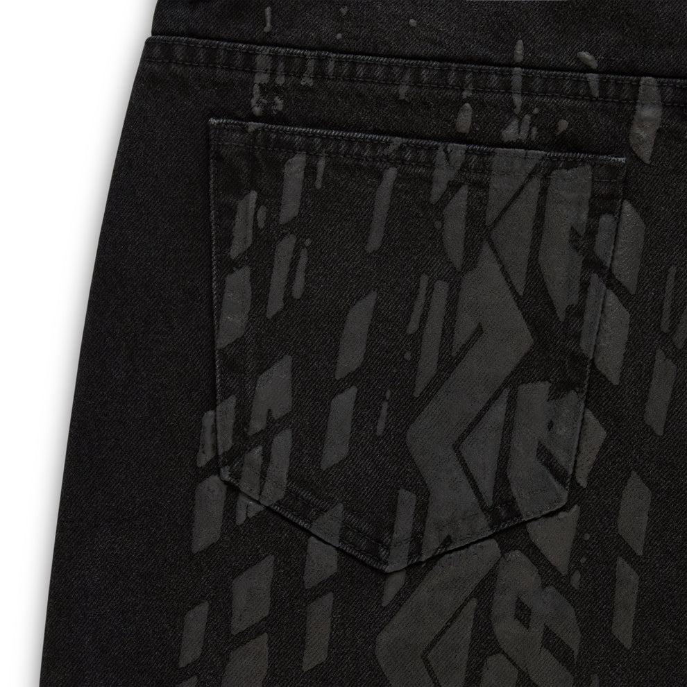 Black denim pant with all-over tire track design, custom hardware, and a back pocket.