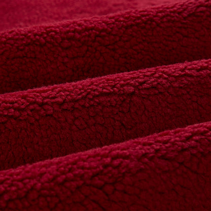 Close-up of soft, textured red sherpa fleece fabric, folded in waves.