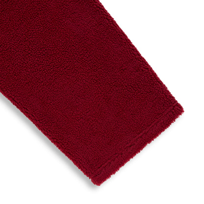 Close-up of a rich red sherpa fleece pant leg, showing the soft, textured material.
