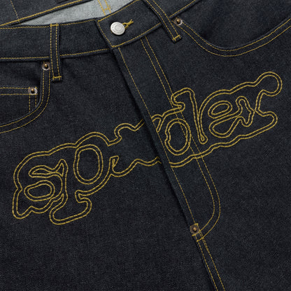 Dark wash denim jeans with yellow embroidered "SP5DER" logo across the crotch.