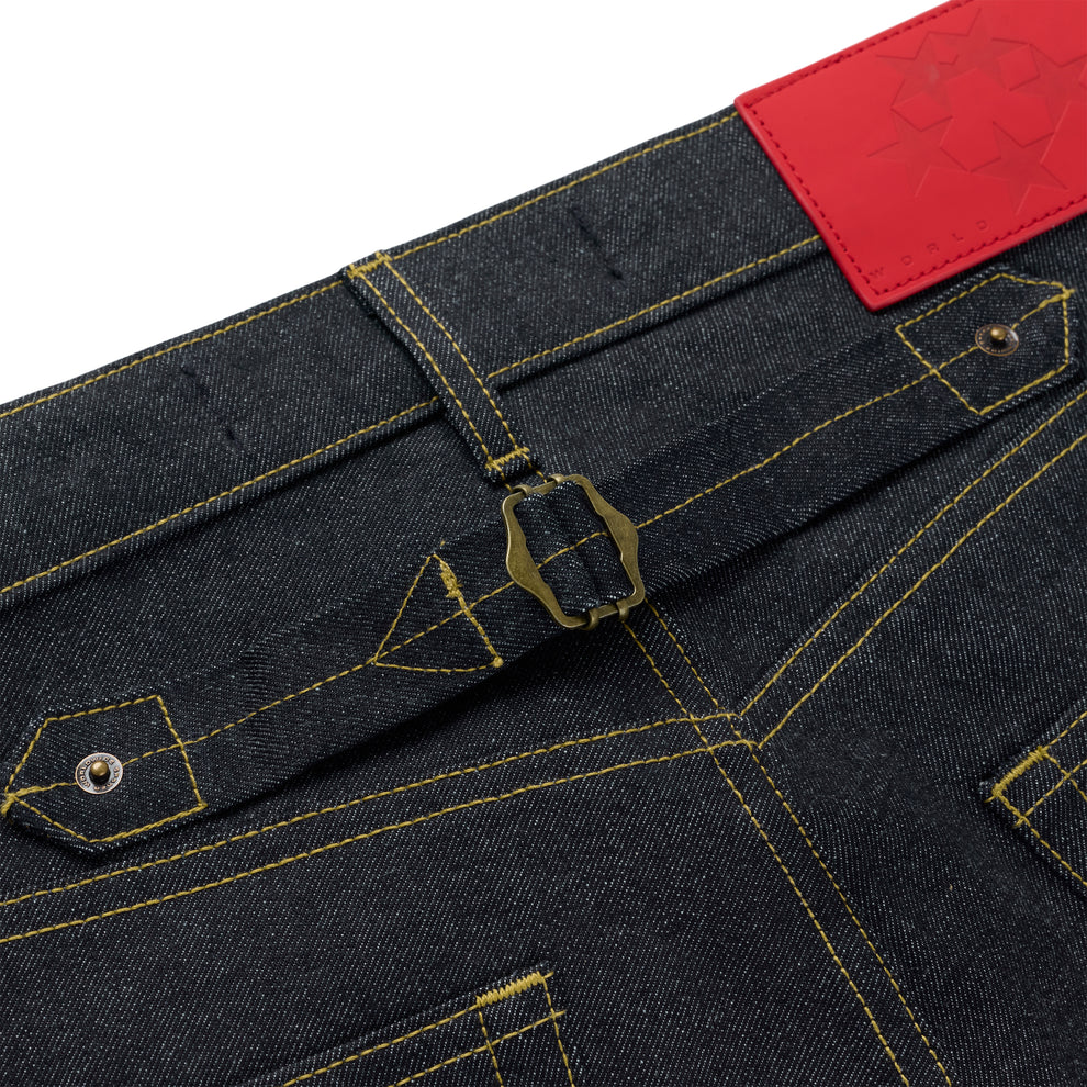 Dark wash denim jeans with yellow stitching, a brass buckle-back cinch, and a red leather back patch.