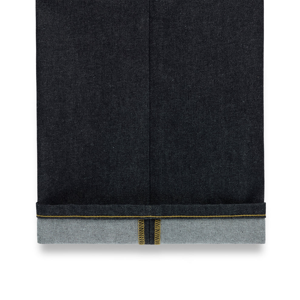 Dark indigo denim jeans with a straight leg fit and a cuffed hem revealing yellow selvedge stitching.