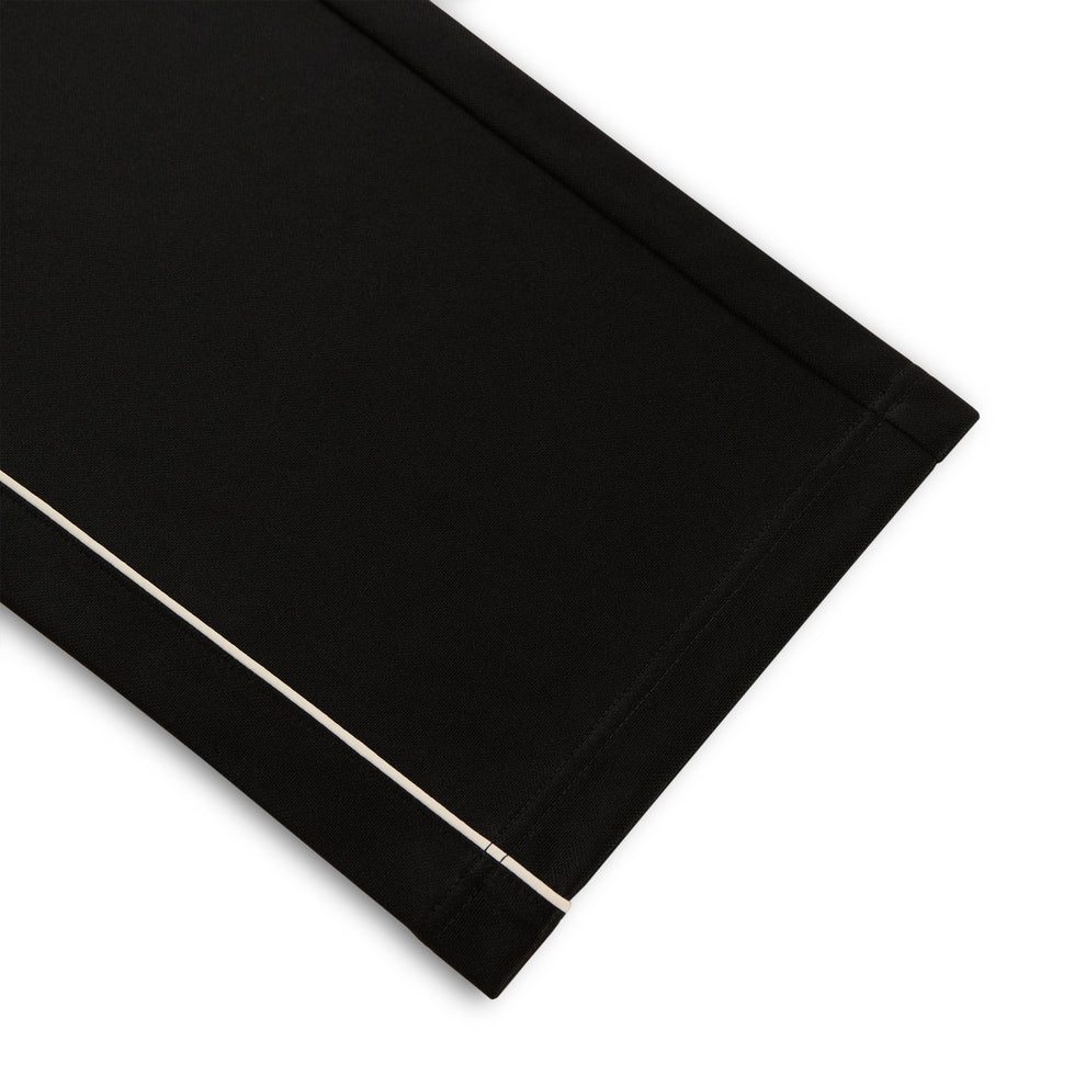 Black polyester Atlanta Track Pant with white contrast piping, wide-leg silhouette.