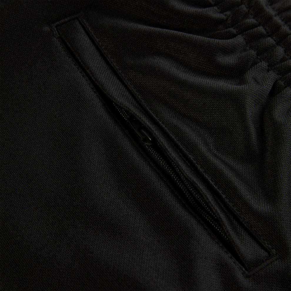 Close-up of black ATLANTA TRACK PANT, showing zippered pocket and elastic waistband.