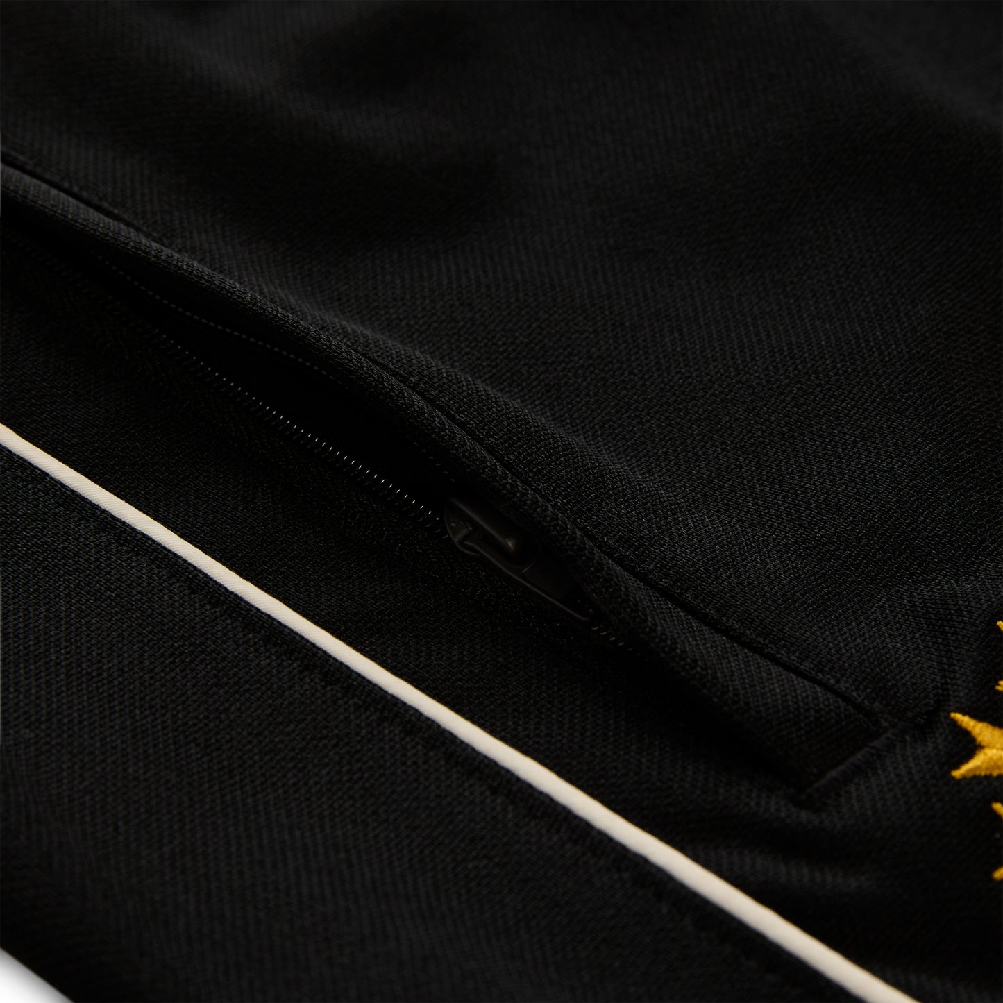 Black polyester Atlanta Track Pant with white side piping and a zippered pocket.