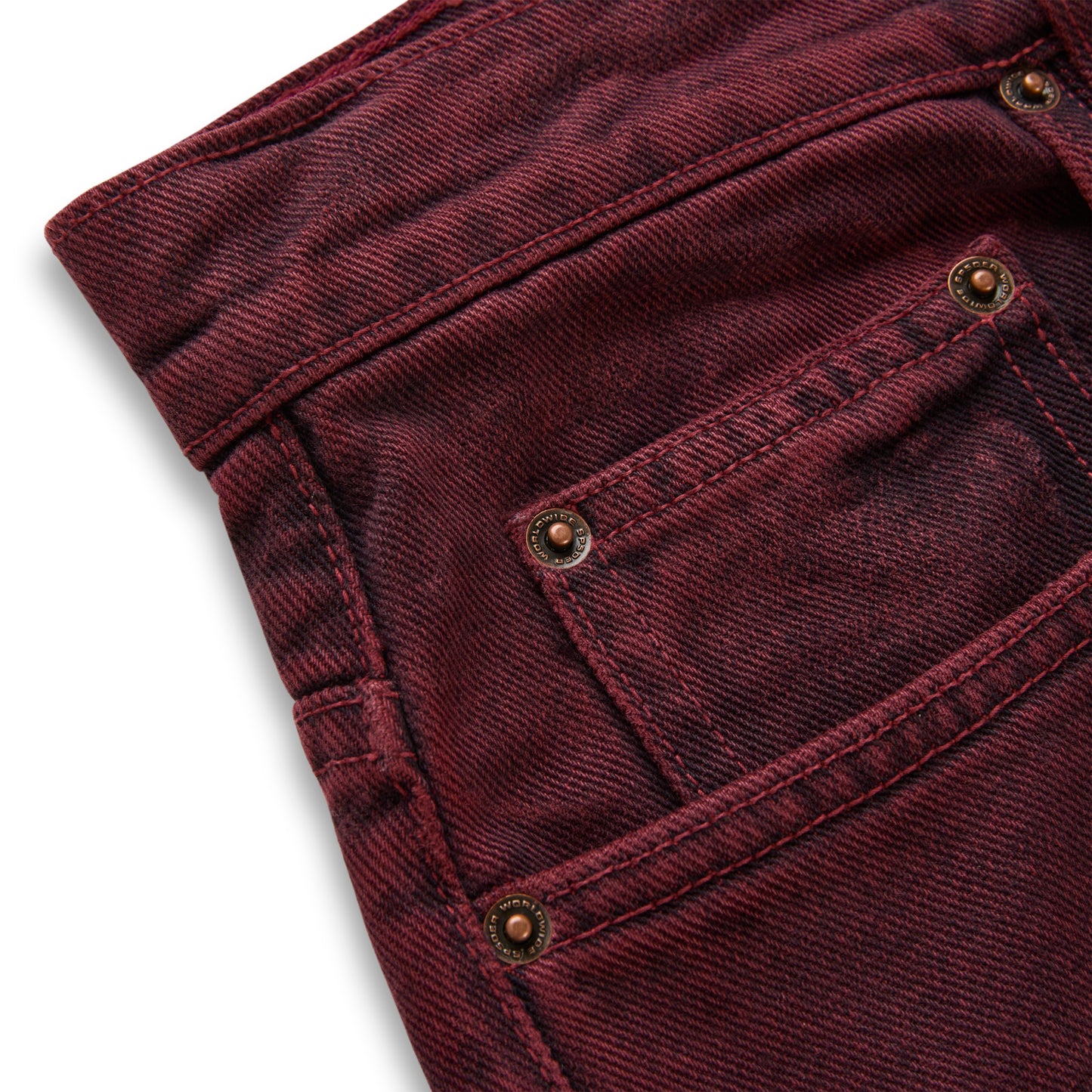 Faded wash burgundy denim pants with custom branded hardware and five-pocket styling.