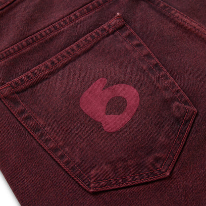 Faded wash red denim pant with a dark red Beluga print on the back pocket.