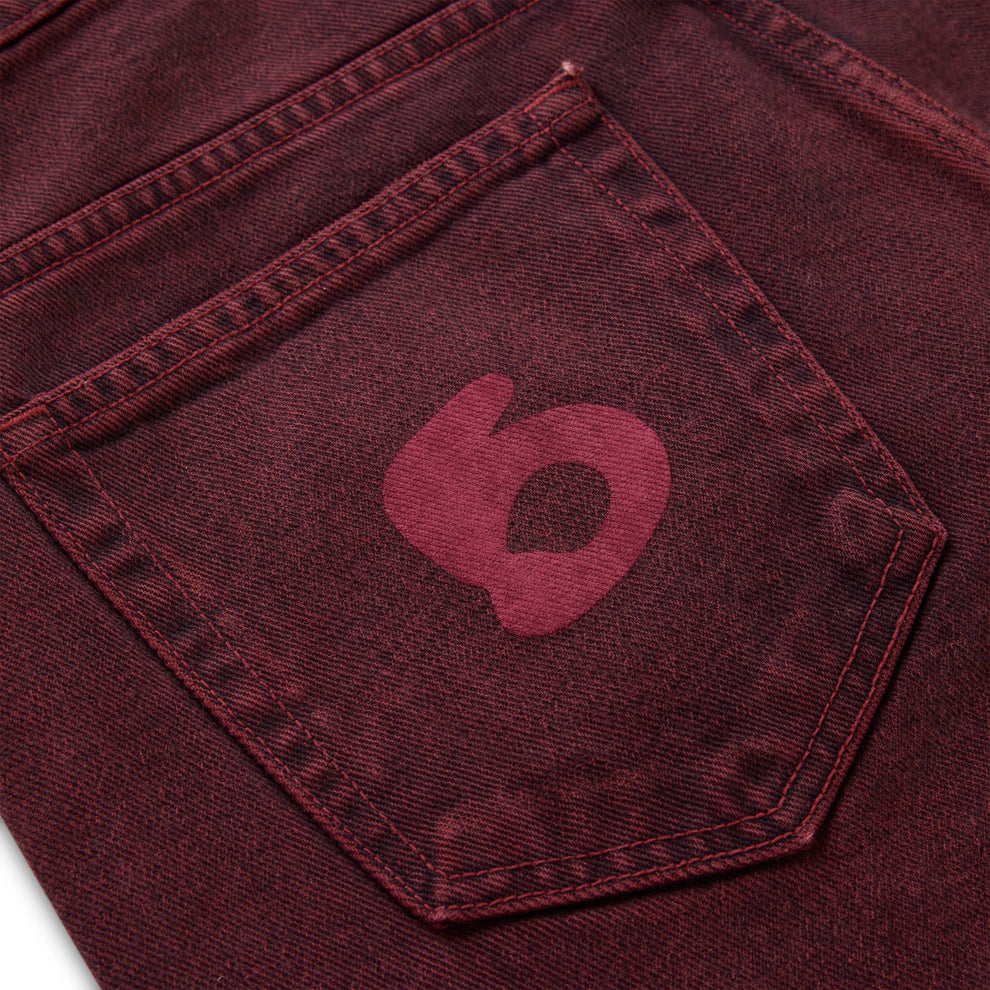 Faded wash red denim pant with a dark red Beluga print on the back pocket.