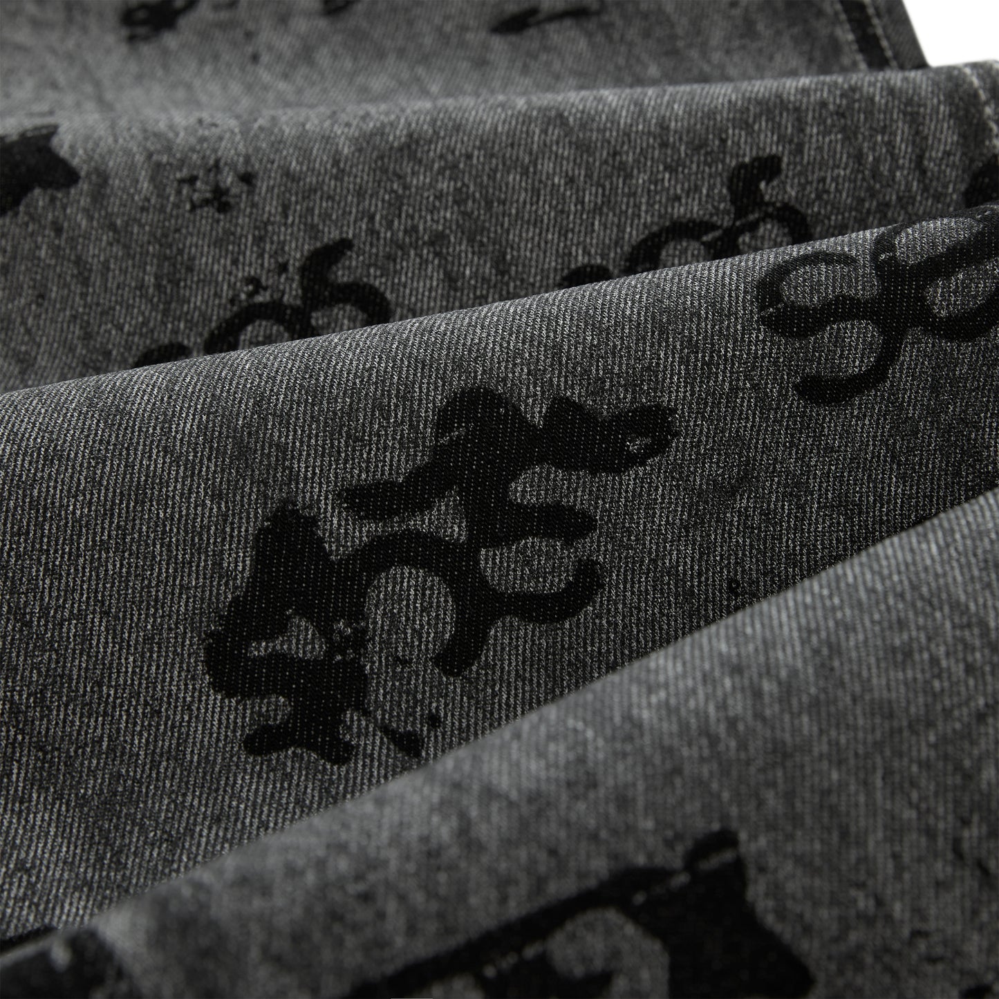 Gray denim pants with black all-over print design and red contrast stitching.