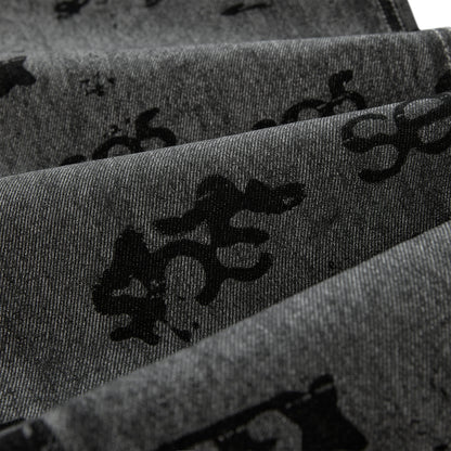 Gray denim pants with black all-over print design and red contrast stitching.