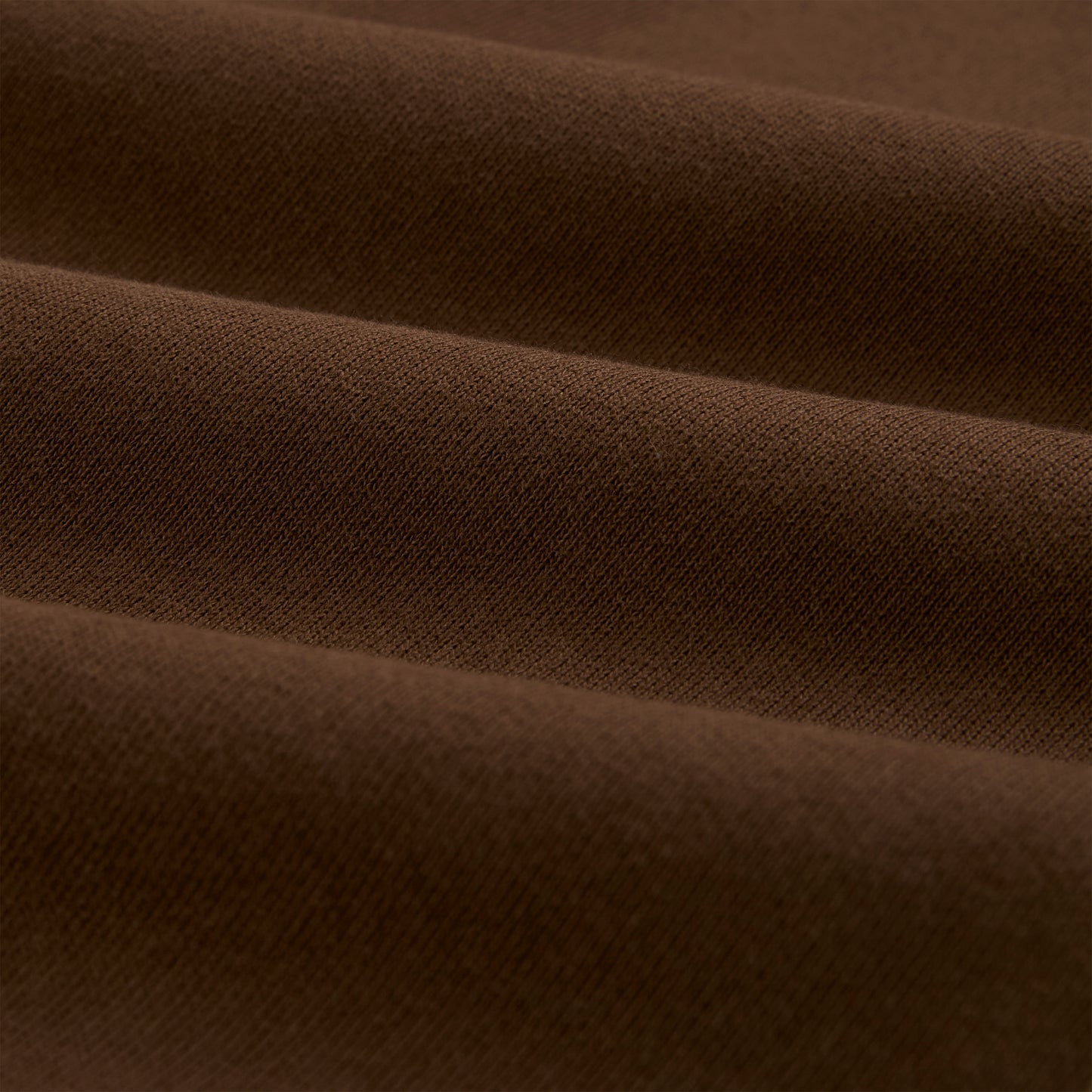 Close-up of brown 13oz cotton fleece fabric, showing its soft texture and folds.
