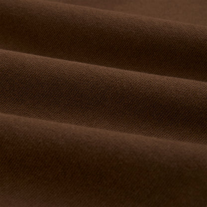Close-up of brown 13oz cotton fleece fabric, showing its soft texture and folds.