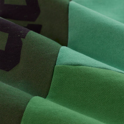 SUPERFIVE SWEATPANT: Close-up of green contrast-paneled 13oz cotton fleece with graphic print.