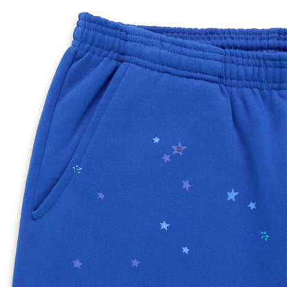 Blue sweatpants with elastic waist, side pockets, and scattered purple star and "S" logo graphics.