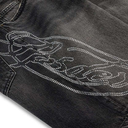 Vintage wash black denim shorts with a large rhinestone web and text design.
