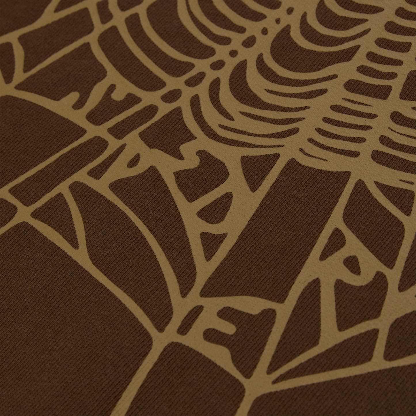 Close-up of a brown cotton fleece hoodie with a tan rhinestone web and text detail.