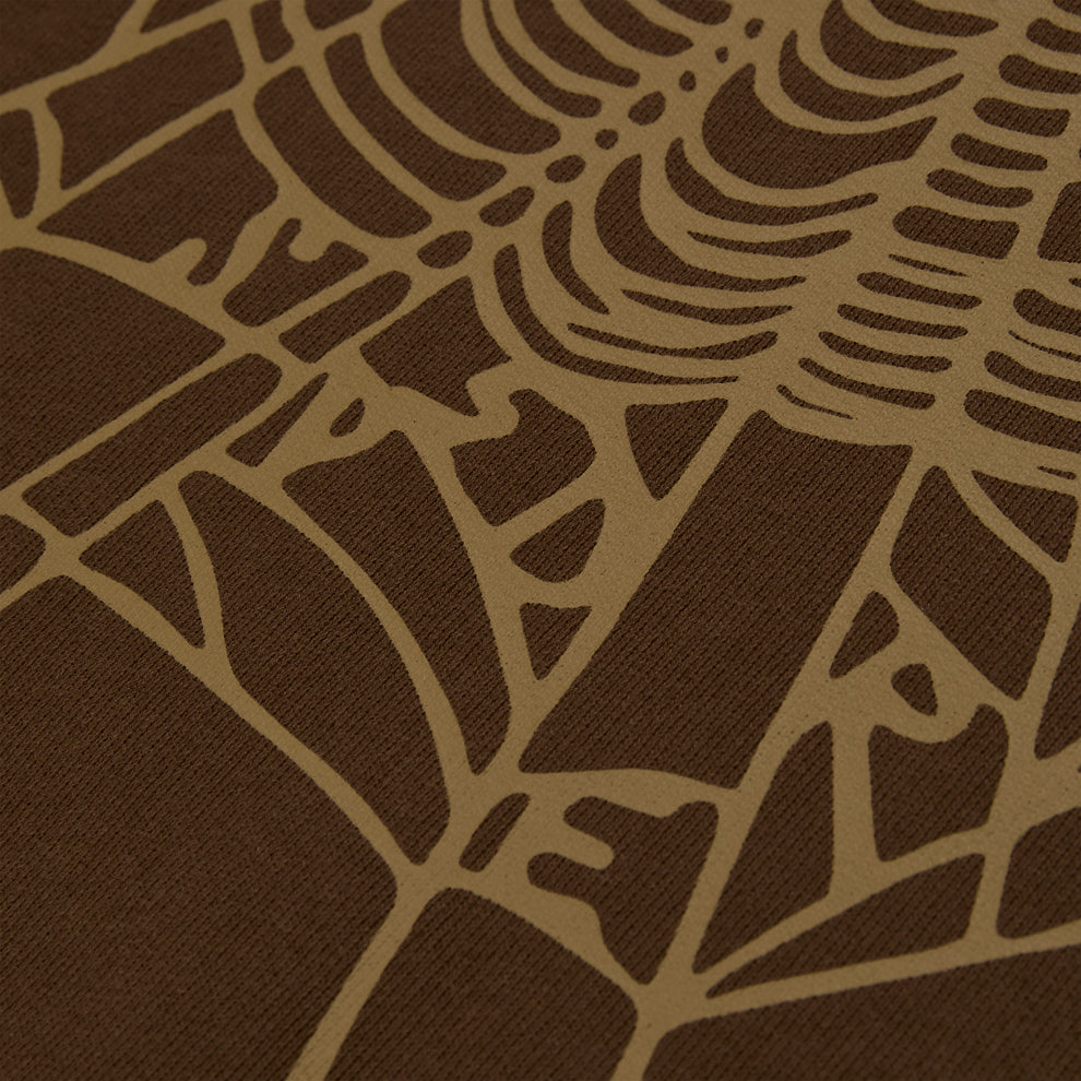 Close-up of a brown cotton fleece hoodie with a tan rhinestone web and text detail.
