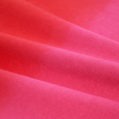 Close-up of a vibrant pink 100% cotton brushed fleece fabric with subtle folds, showcasing its soft texture.