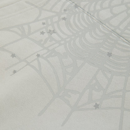 Close-up of a light gray cotton fleece hoodie with a subtle spiderweb and scattered star print.