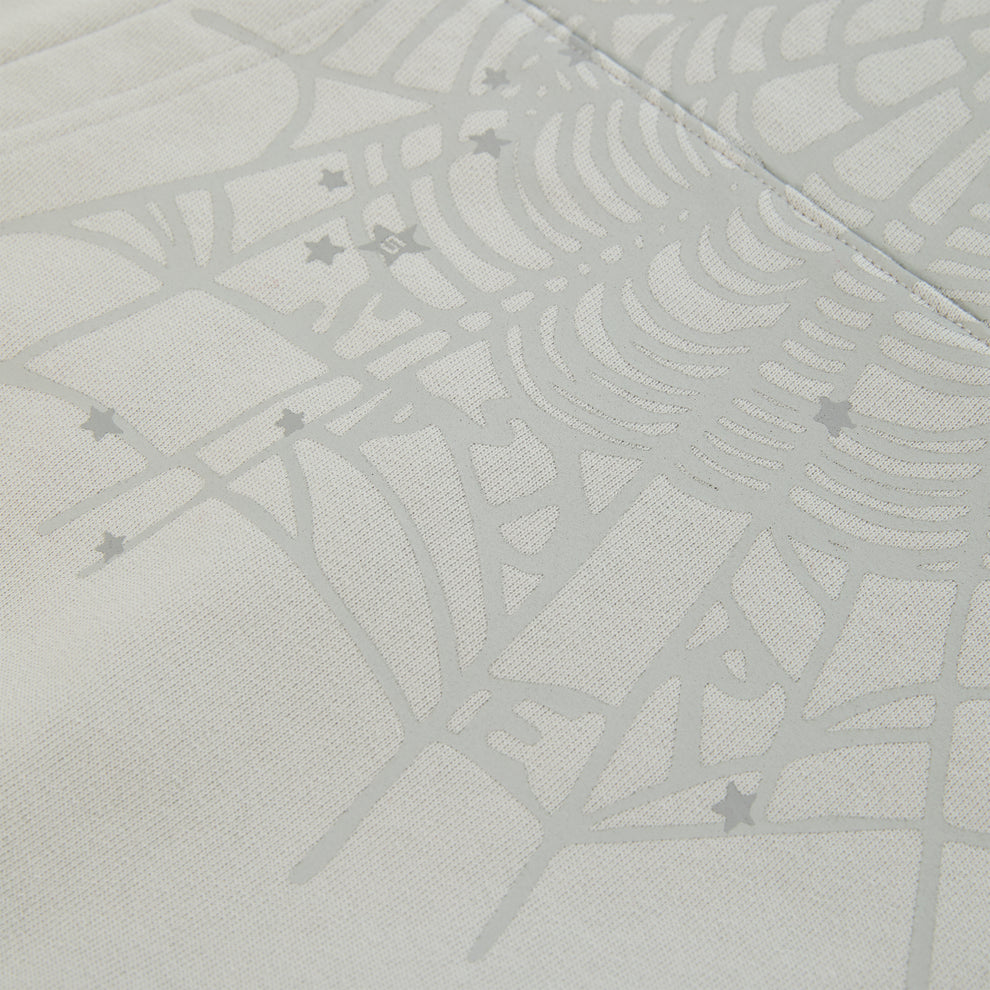 Close-up of a light gray cotton fleece hoodie with a subtle spiderweb and scattered star print.