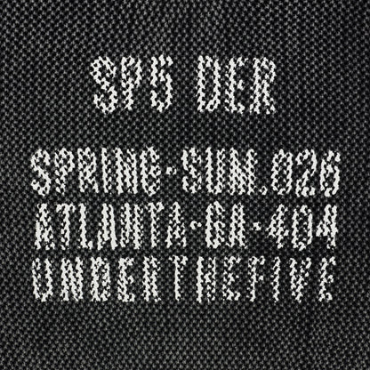 Black knit cotton sweater with white "UNDERTHEFIVE" text print and other details at chest.