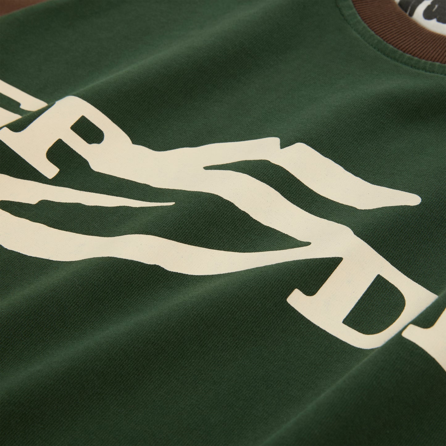 Green 5UKI TEE with cream graphic print, brown collar, and color-block design.