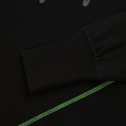 Black cotton long sleeve tee with ribbed cuff and bright green contrast stitching.
