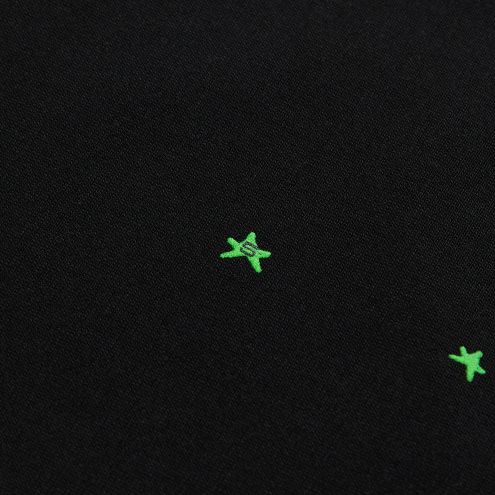 Black 100% cotton tee with embroidered green star and "S" graphic.