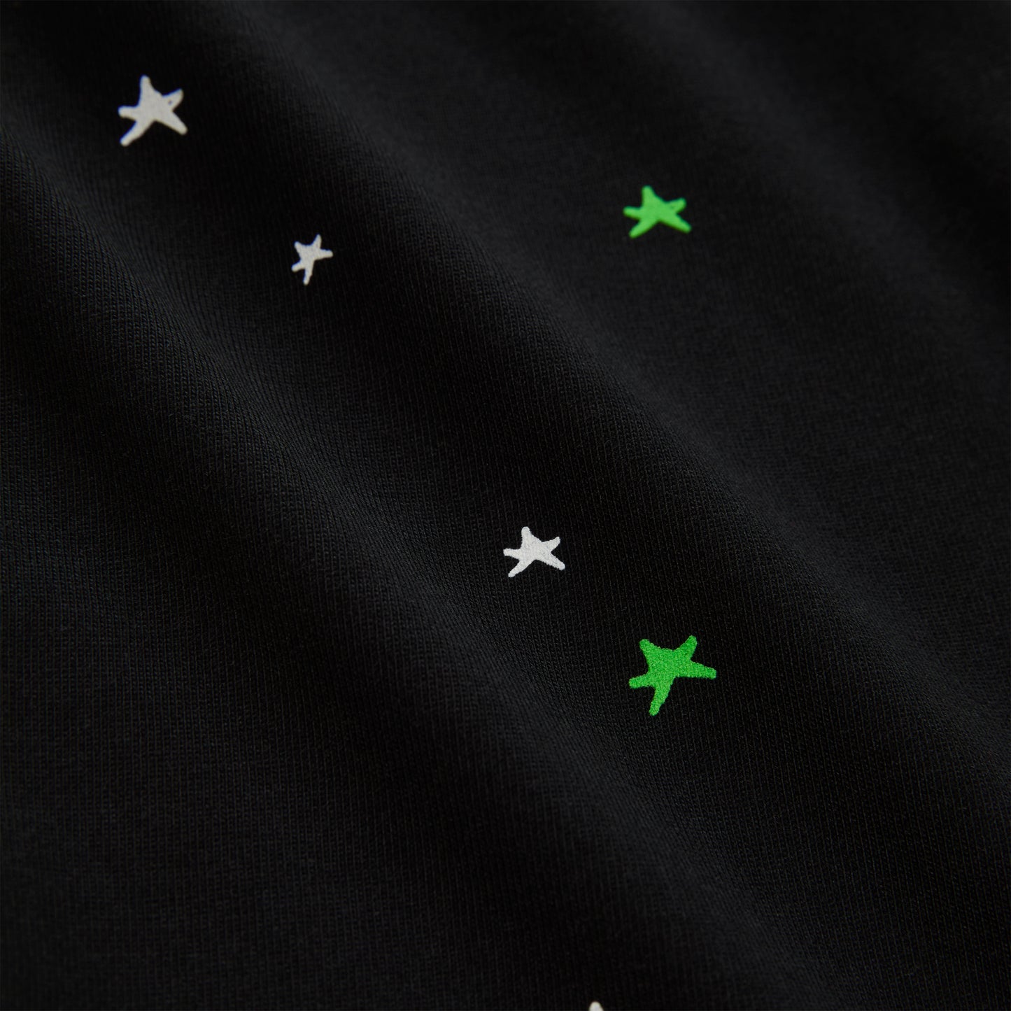 Black 100% cotton lightweight tee with white and green star print.