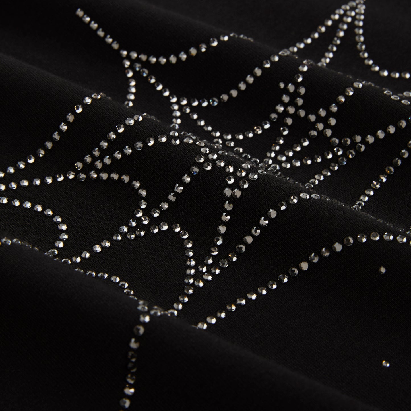 Black cotton tee with sparkling rhinestone spiderweb graphic.