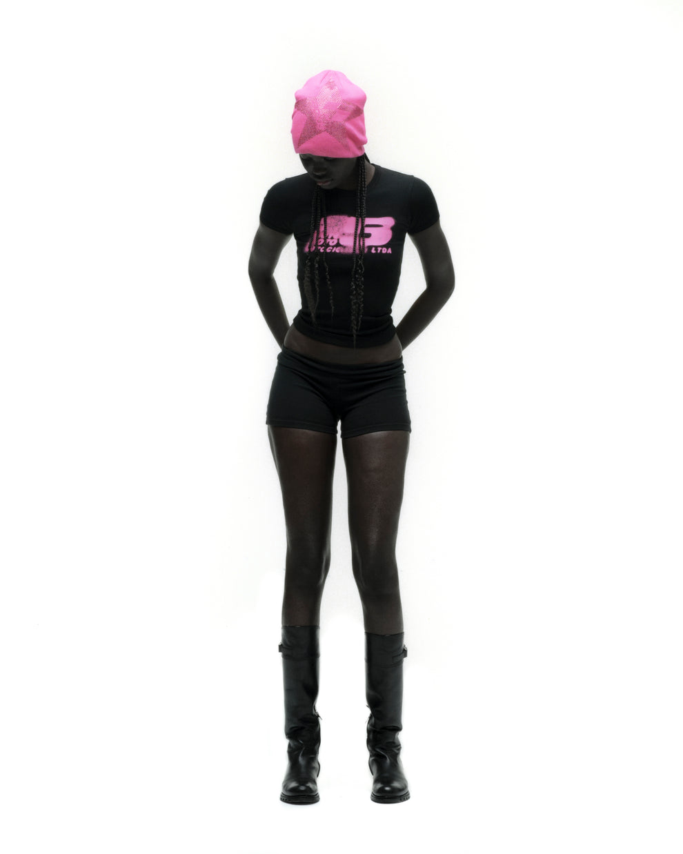 Black cropped MOTO 5 BABY TEE with pink graphic print, worn by a model with a matching pink beanie.