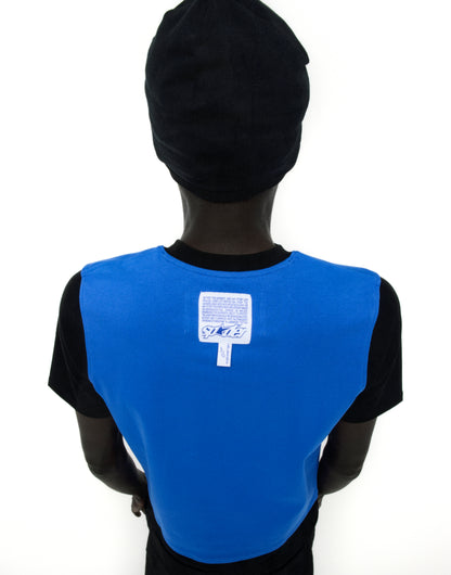 Back of a person wearing a black Engineer Tee with a blue panel, white graphic, and woven logo label.