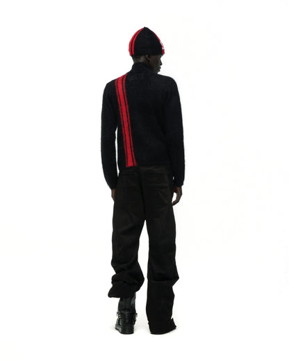 Black mohair knit zip sweater with a red vertical stripe, worn with a matching beanie.