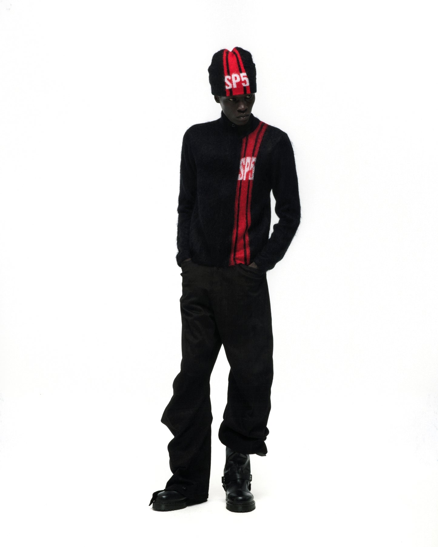 Black mohair knit zip sweater with red vertical stripe and "SP5" logo, paired with matching beanie and black pants.