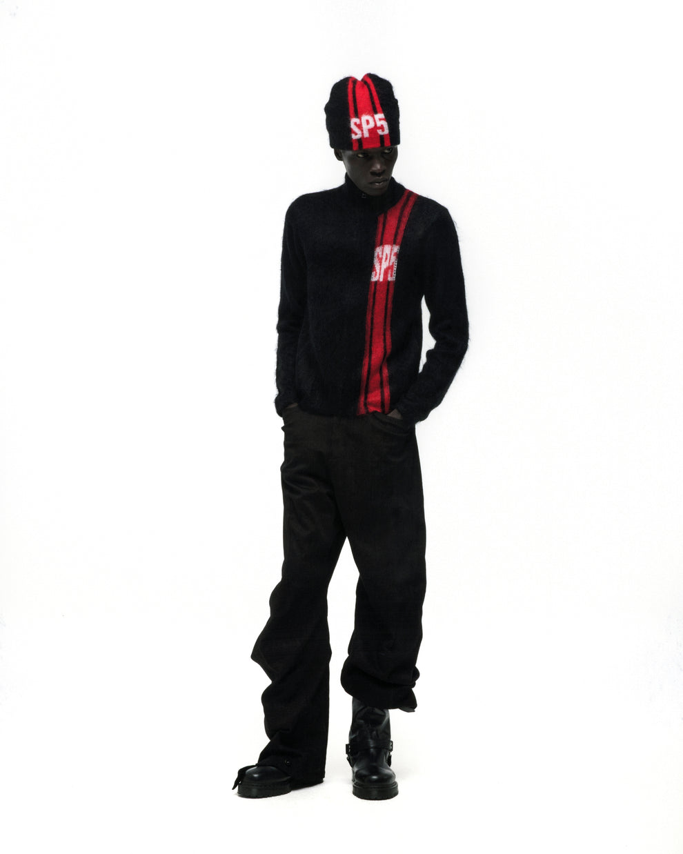 Black mohair knit zip sweater with red vertical stripe and "SP5" logo, paired with matching beanie and black pants.