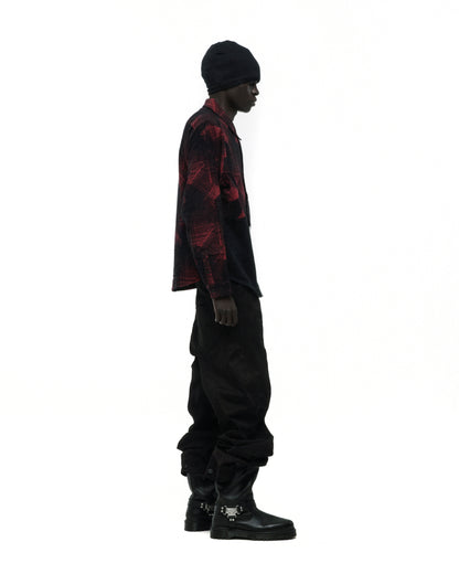 Model in red and black plaid cotton flannel shirt with SP5 graphic, black pants, beanie, and buckle boots.