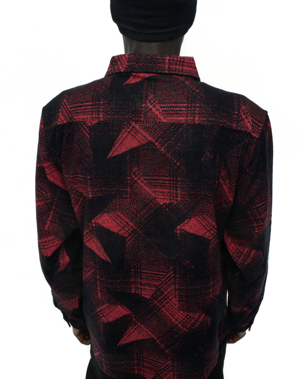 Back of a red and black cotton flannel shirt with a plaid and paneled SP5 graphic design.